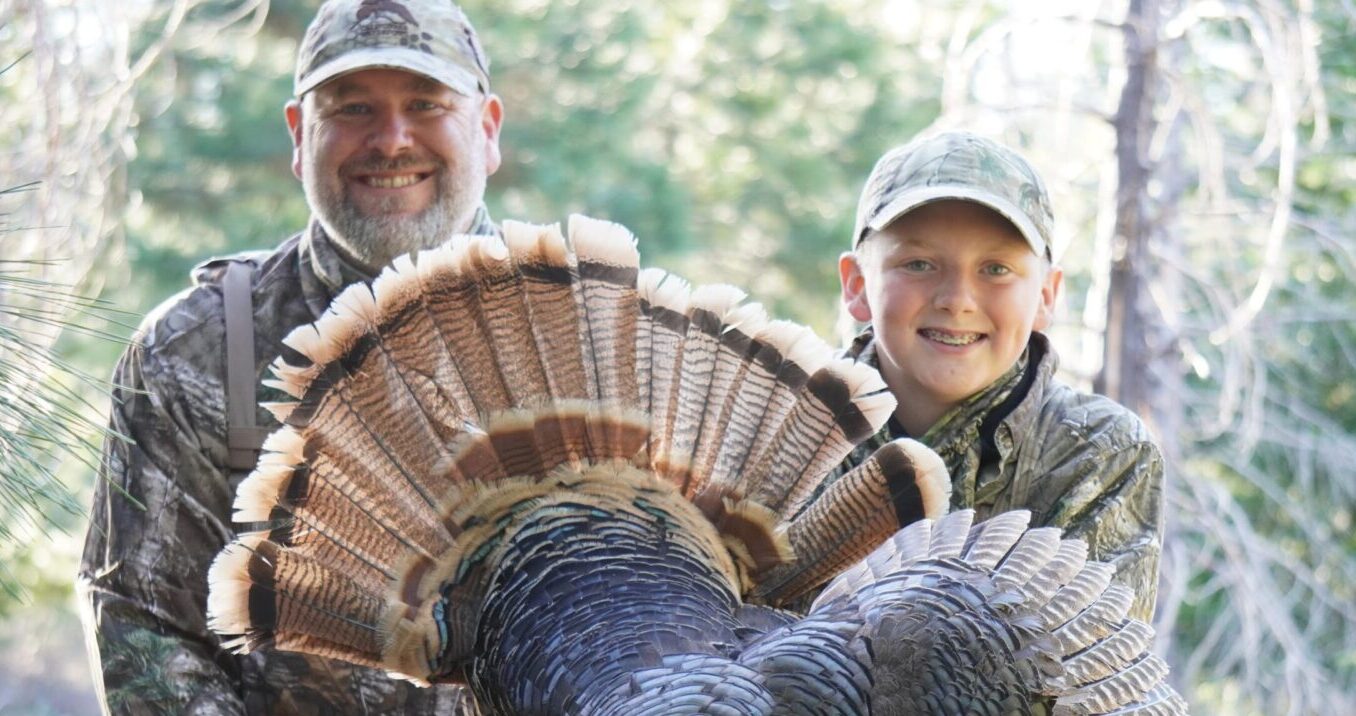 Dad and kid with wild turkey